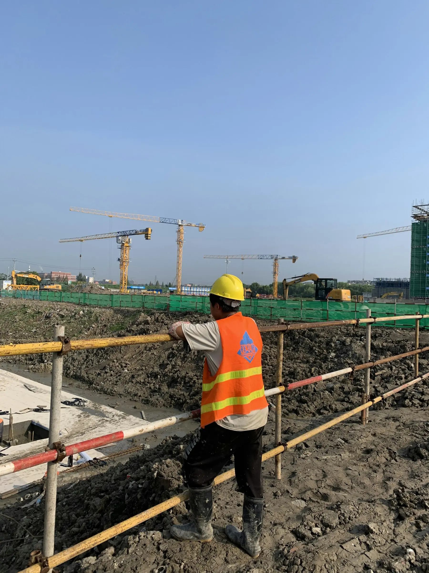 Site engineer at a construction site with cranes