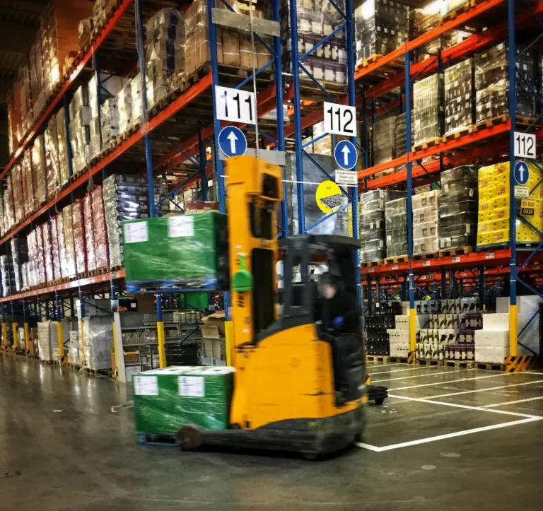 Forklift moving pallets in a distribution warehouse
