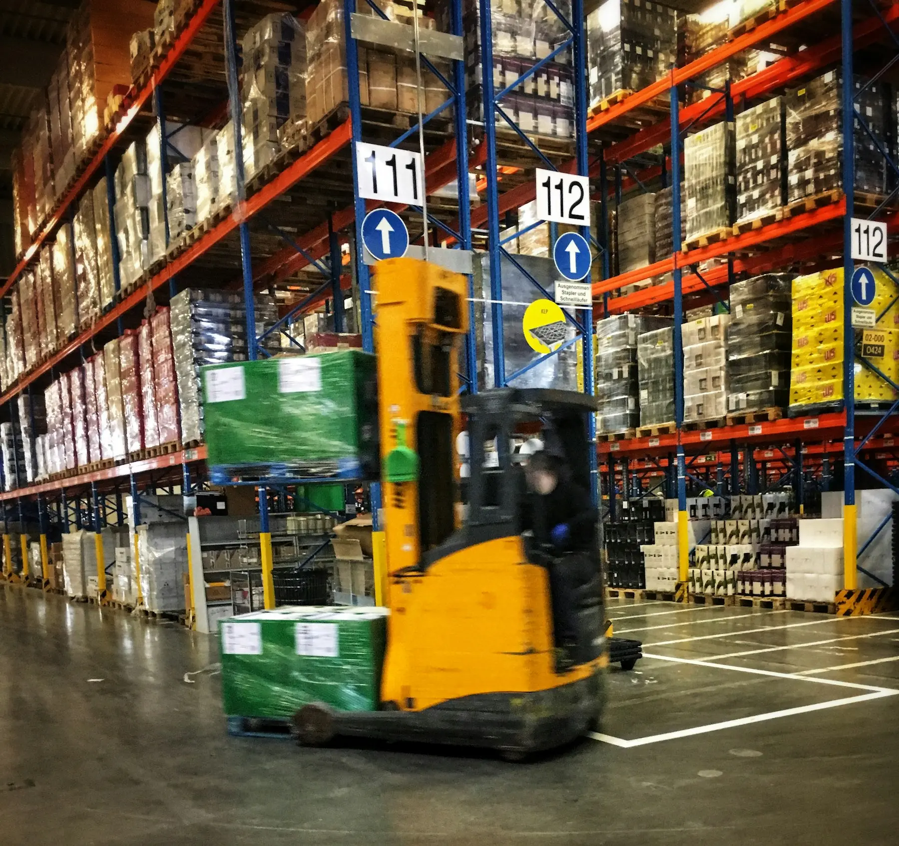 Forklift moving pallets in a distribution warehouse