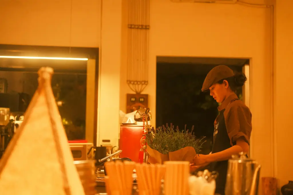 Barista preparing drinks behind a cafe counter